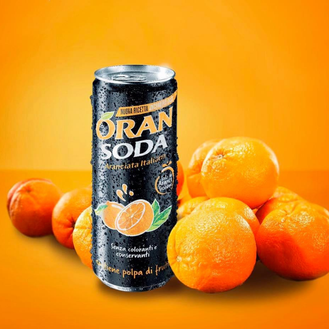 A can of oran soda among oranges